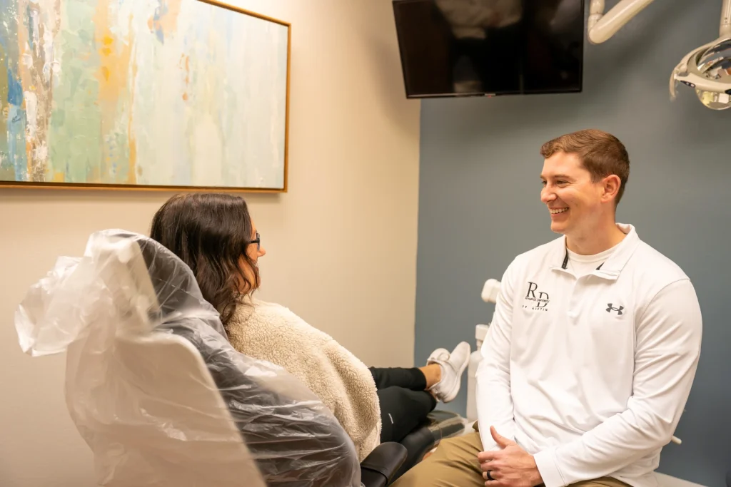 Dr. Austin Rickabaugh interacting and smiling with a happy patient in the dental chair | Locally-owned dentist in Lenexa, KS